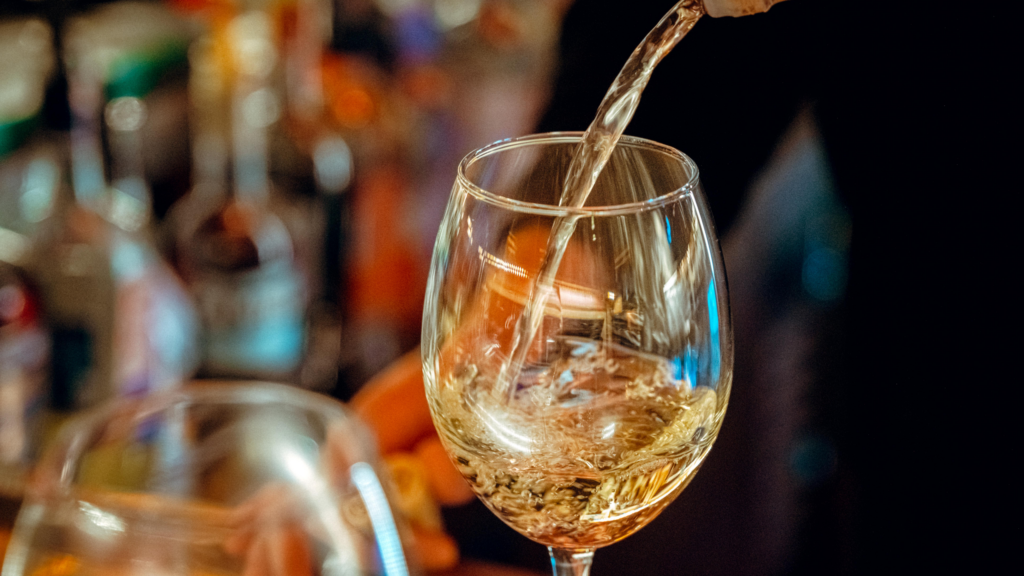 Chardonnay being poured into a wine glass at an On-Premise bar